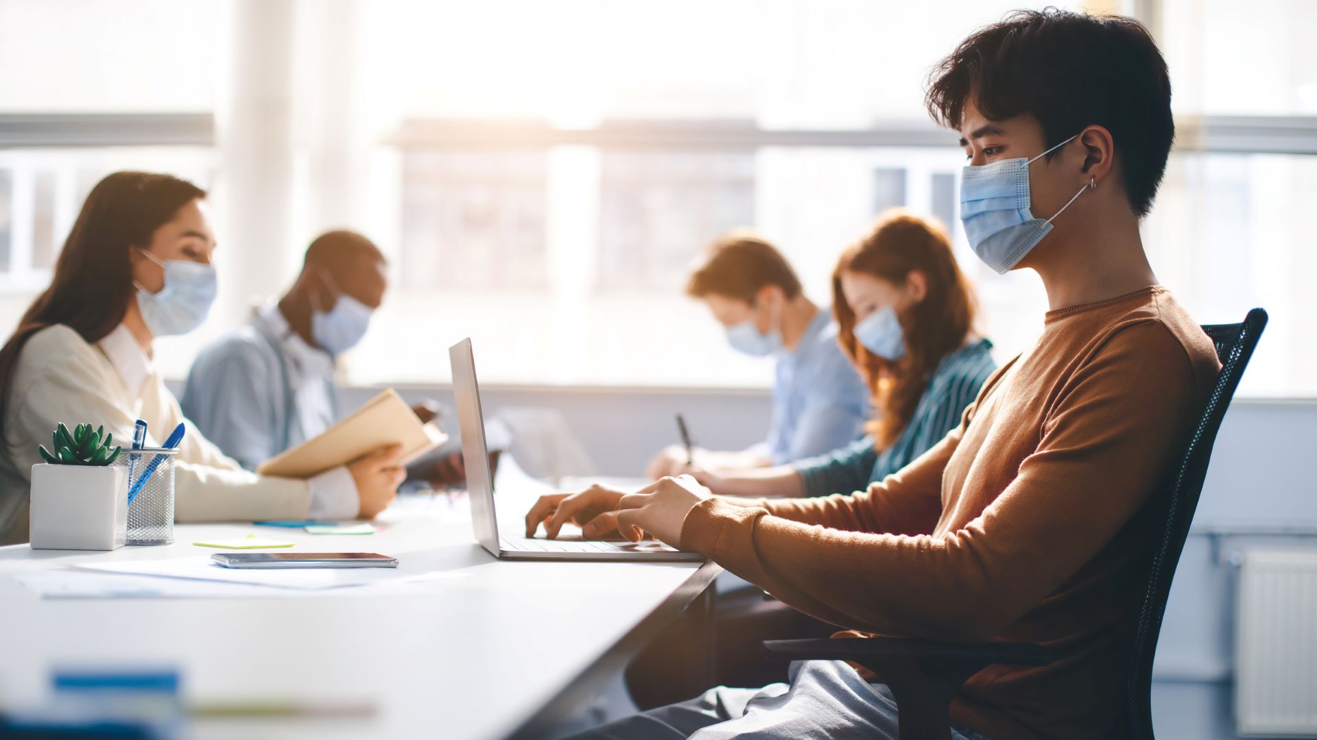 masked students working on computers