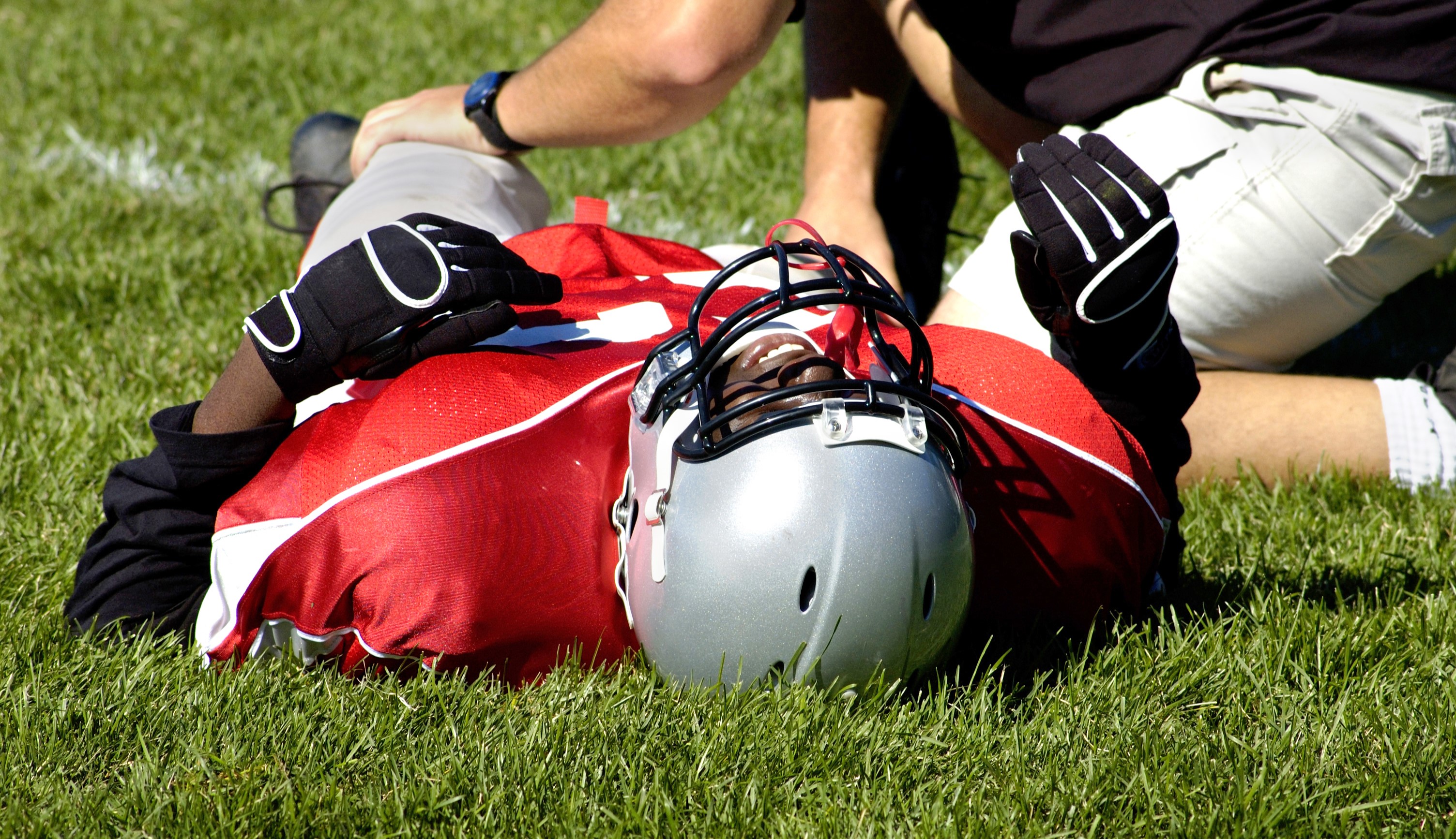 injured football player receiving treatment on the field