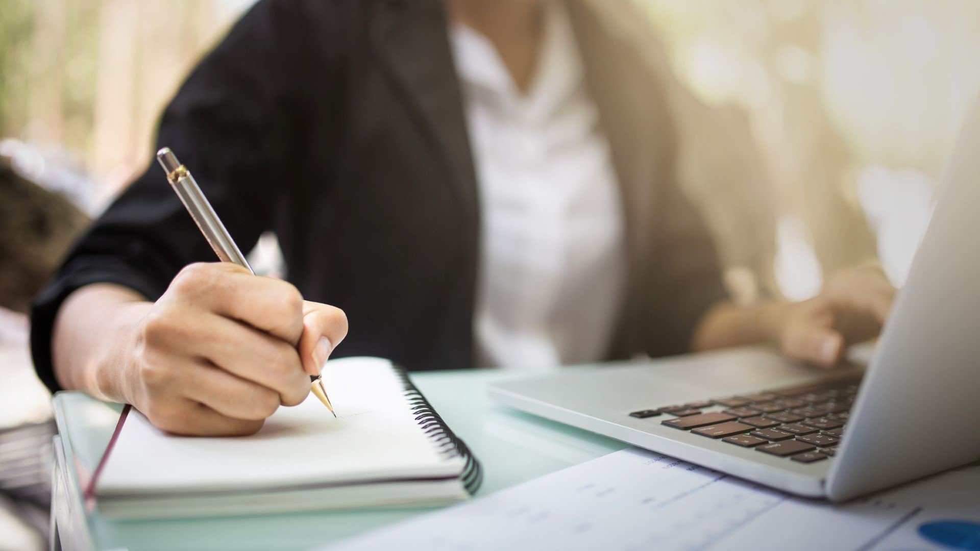 person on computer taking notes