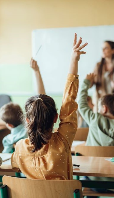 child raising hand in class