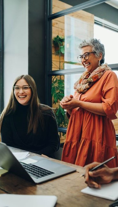 two coworkers talking and smiling
