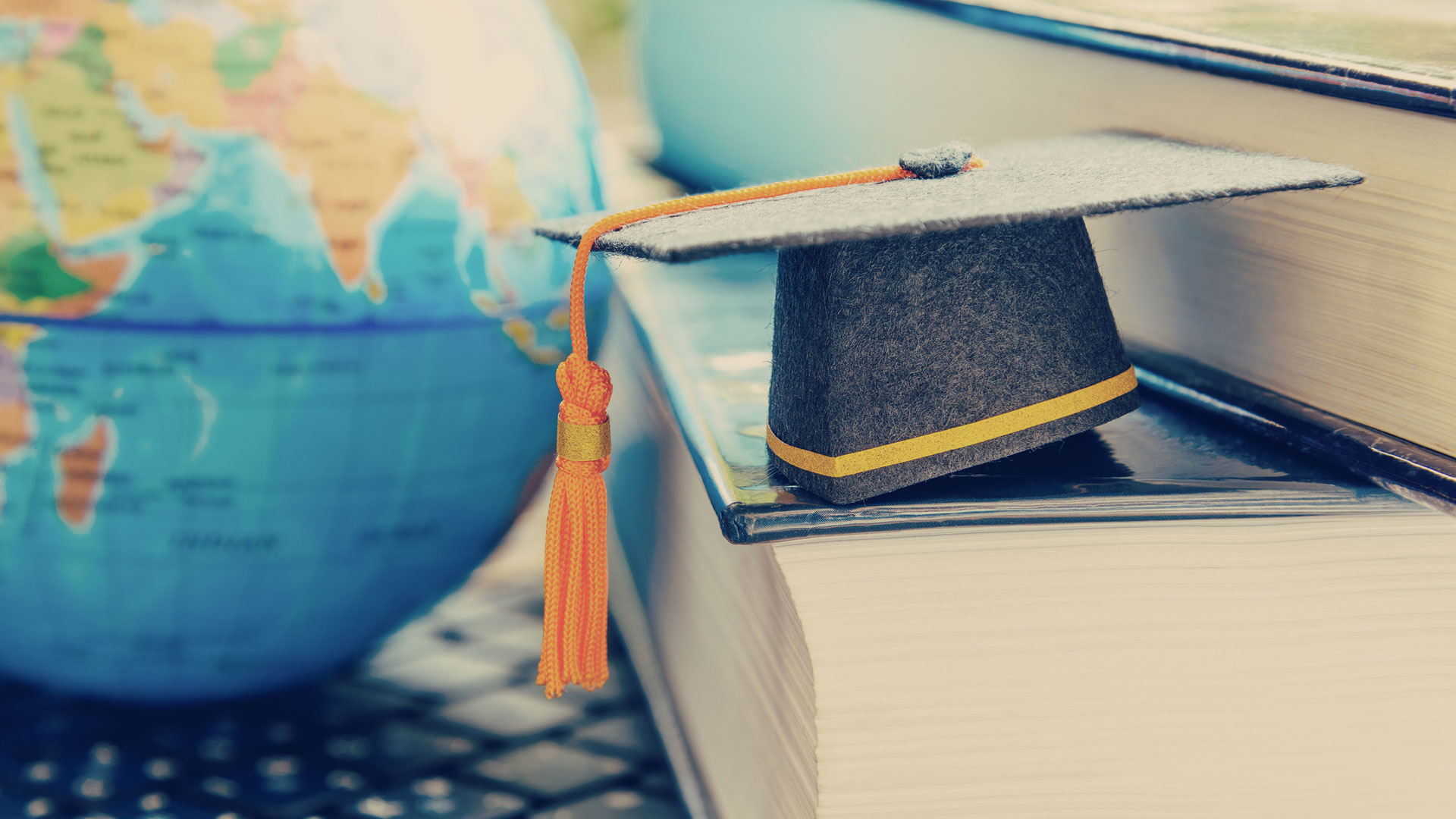 Close up of globe and graduation cap