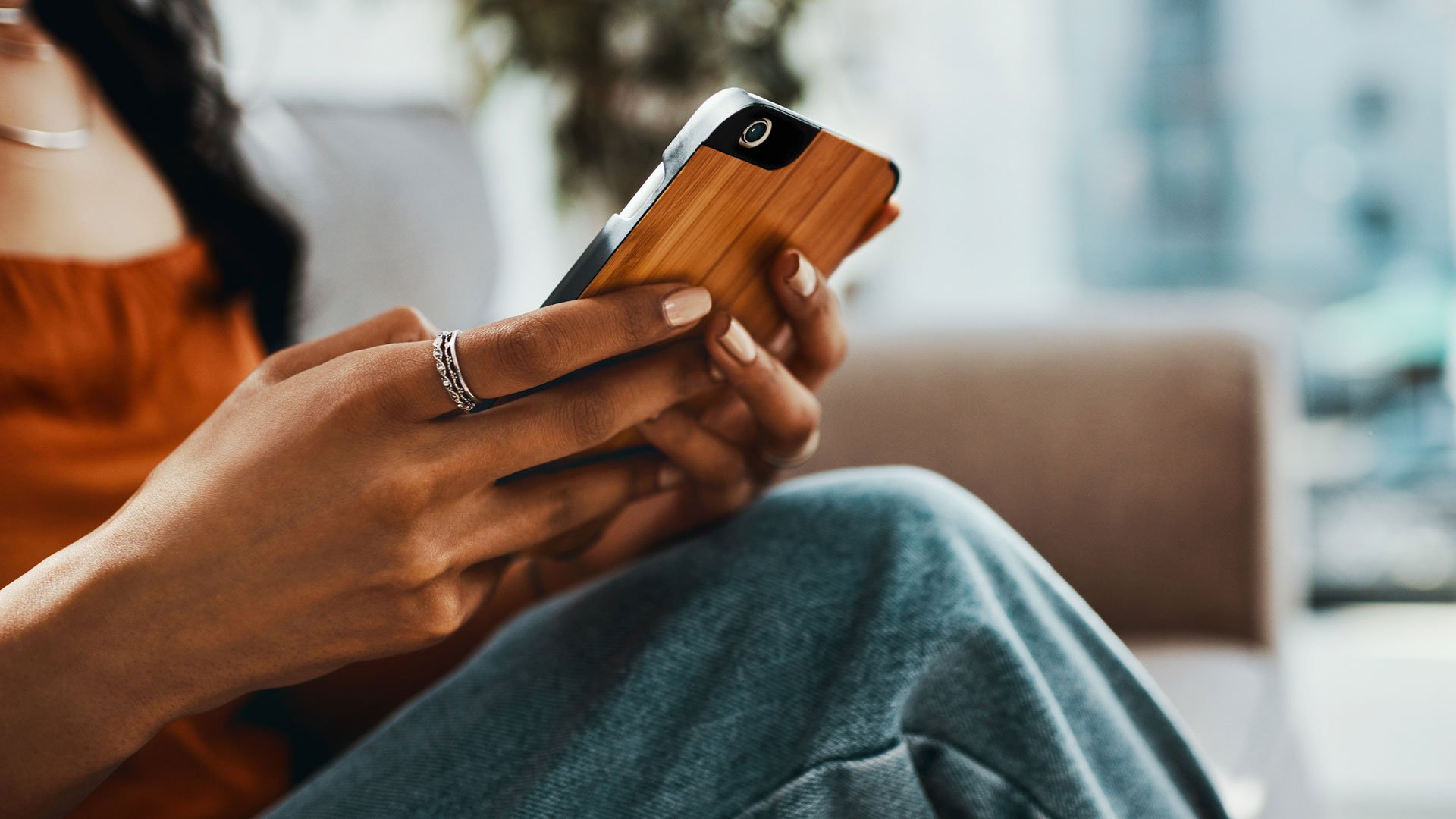 person sitting legs crossed texting on the phone