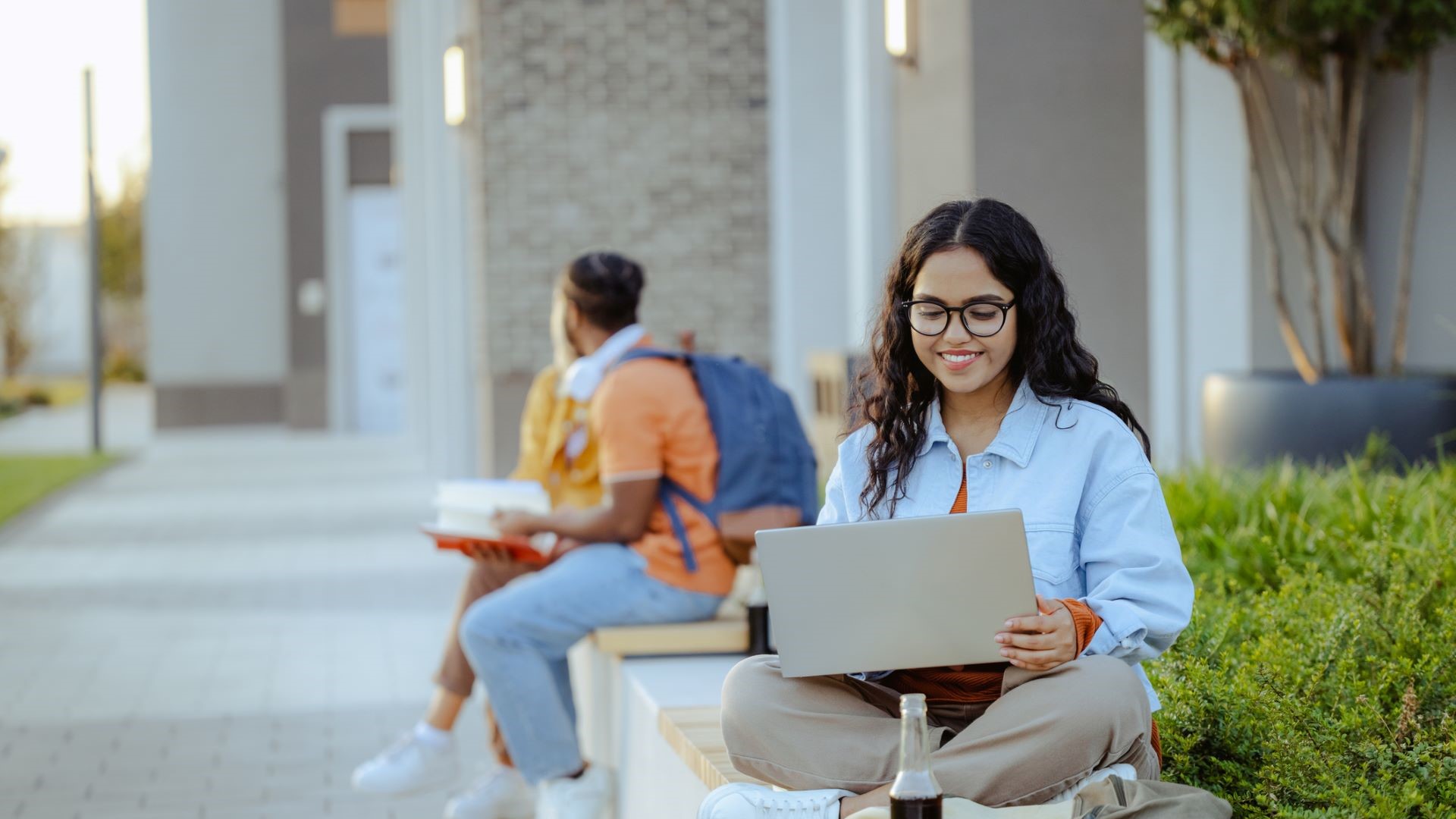 student sitting outside on laptop